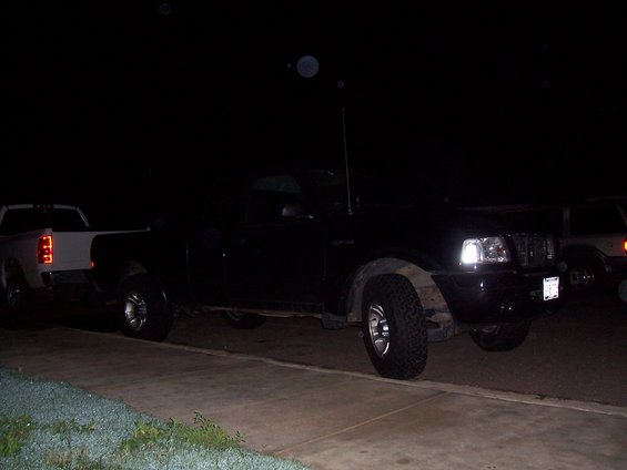 Black 2003 Ford Ranger pickup truck parked at night, front passenger side visible