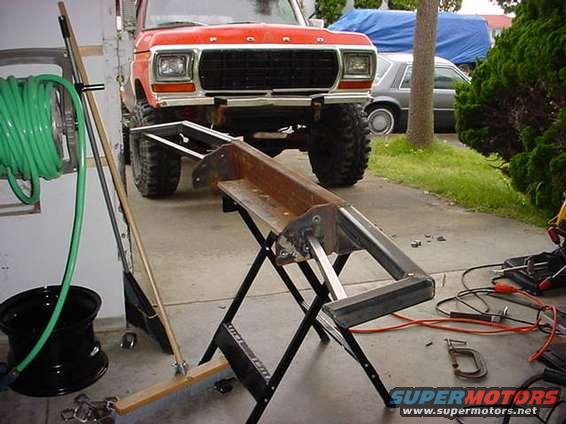 Red 1979 Ford Bronco with large tires, lifted suspension, and a black grille, viewed from the front