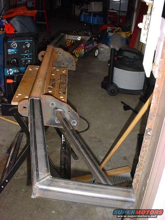 Miller welding machine, metal brackets, and a shop vacuum in a garage