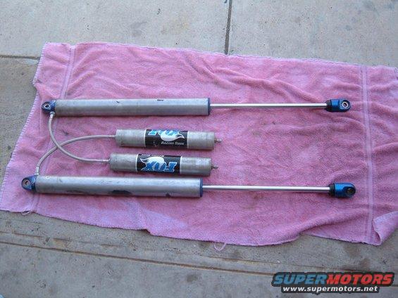 Four Fox Racing Shox with blue accents laid out on a pink towel