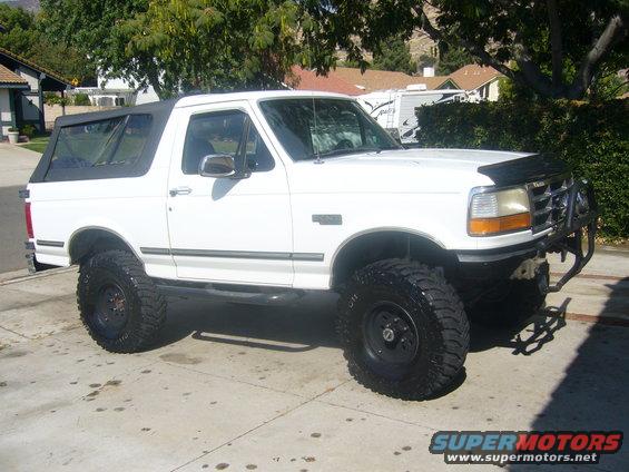 1992 Ford Bronco, lifted with off-road tires, parked on a driveway