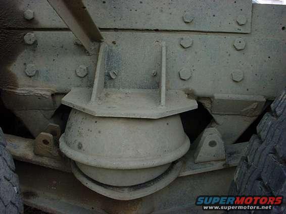 Truck chassis suspension component with visible bolts and rubber isolator