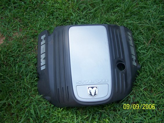 Black engine cover with silver insert, "HEMI" and "5.7L V8" text, and Dodge Ram logo