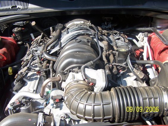 engine bay with hoses and wiring visible, date stamp 09/09/2006