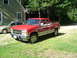 1990 Chevrolet C/K Pickup - This red 1990 Chevrolet C/K Pickup truck is parked in a grassy yard next to a house.