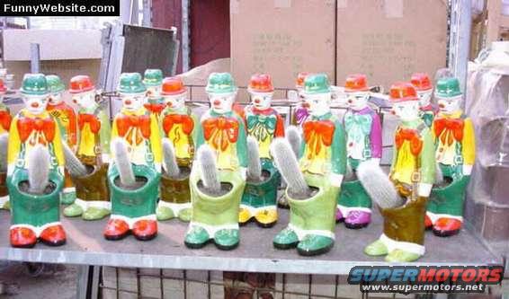 Row of colorful clown planters holding cacti on a shelf