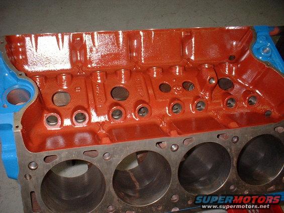 Engine block with cylinders visible, painted orange and blue