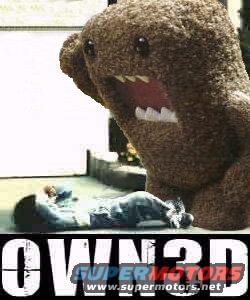 Large Domo-kun plush toy with mouth open, looming over a person lying on the ground. Text 'OWN3D' and 'SUPERMOTORS.NET' visible