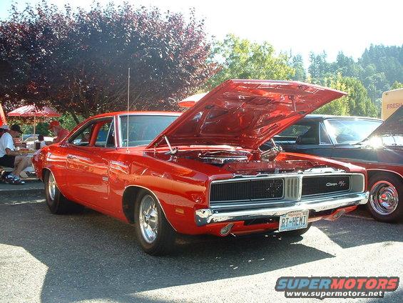 Red 1969 Dodge Charger with hood open, parked next to another car