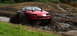 1979 Ford Bronco - Modified red car with snorkel exhaust pipes navigates a muddy obstacle course.