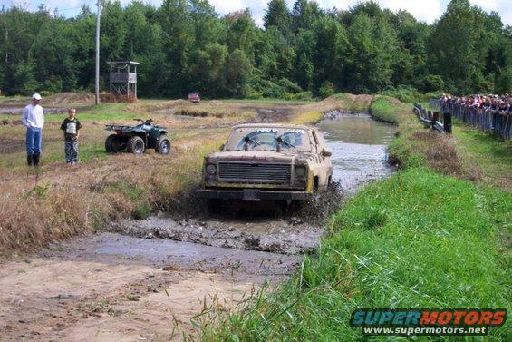 Muddy 1973 Chevrolet K5 Blazer driving through a mud pit, front view