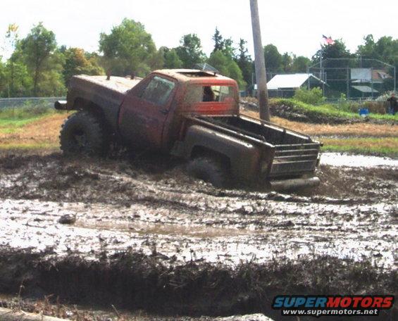 red pickup truck stuck in mud pit, sun roof open
