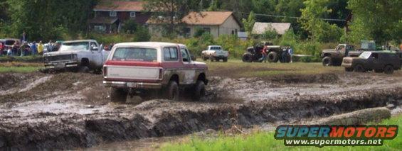 Red and white 1978 Ford Bronco in mud
