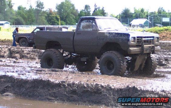 Lifted pickup truck stuck in mud with another vehicle behind it