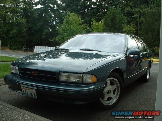 Dark green sedan with a red Chevrolet badge on the grille, parked on a paved surface