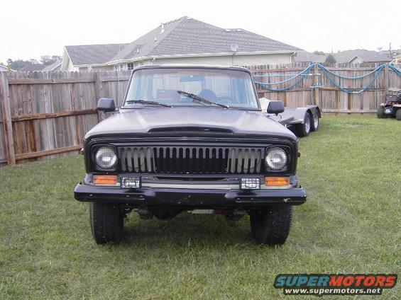 Black Jeep Wagoneer front view with vertical grille and round headlights