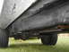 1977 Jeep Wagoneer - Underside view of vehicle frame, leaf springs, and rear axle with tires.