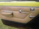 1977 Jeep Wagoneer - The interior door panel features tan upholstery, chrome trim, and a chrome door handle and window crank.