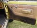 1977 Jeep Wagoneer - Close-up of a vintage Jeep Wagoneer's interior door panel, showing tan upholstery and chrome accents.