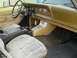 1977 Jeep Wagoneer - The interior of a 1977 Jeep Wagoneer features a tan dashboard, cloth seats, and a center console.