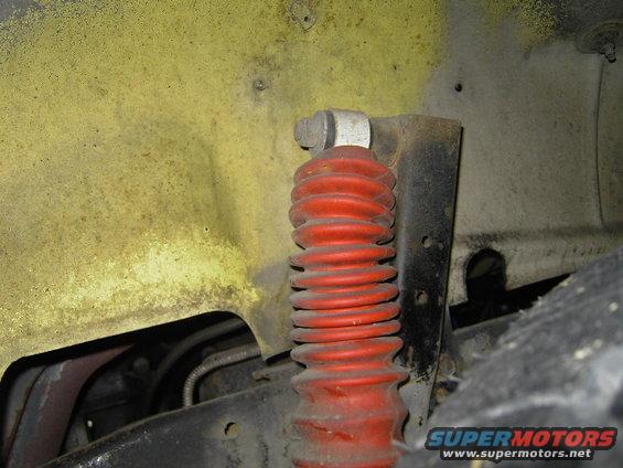 Yellow fender well with a red shock absorber and visible suspension components
