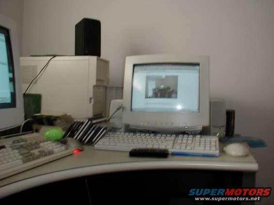 Desk with two computer monitors, keyboards, speakers, and a tower