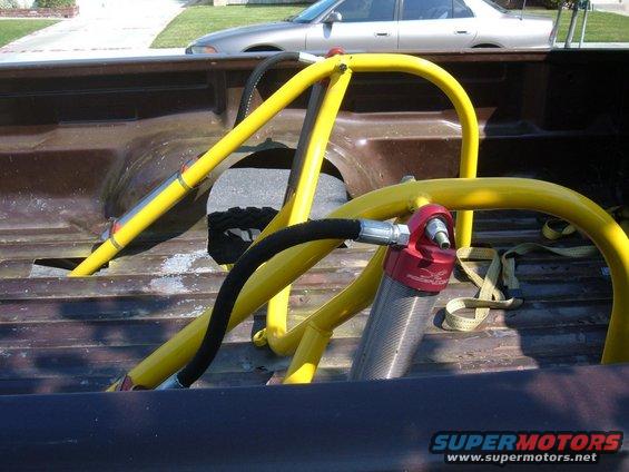 Yellow roll cage and red shock absorber in truck bed