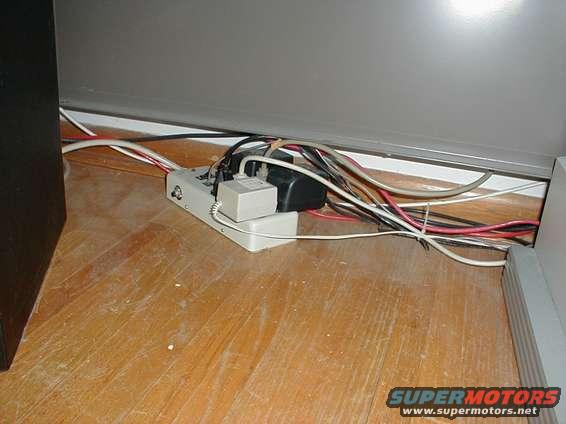 power strip with many cables plugged in on a wooden floor