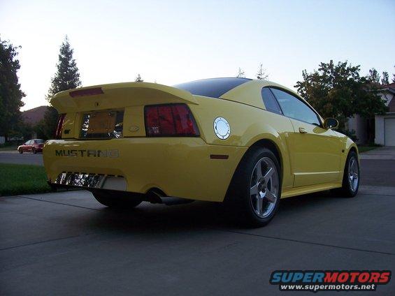 Yellow 2002 Ford Mustang rear view with spoiler and chrome exhaust tips
