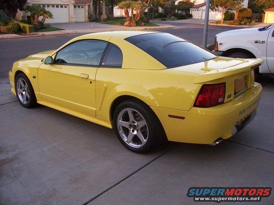 Yellow 2002 Ford Mustang GT parked in a driveway