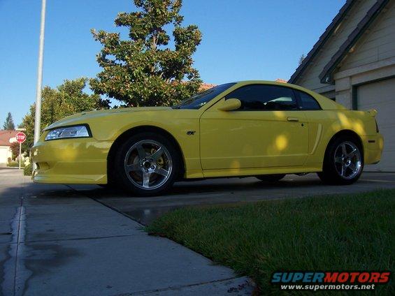 Yellow coupe with GT badge, parked on a driveway