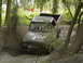 1988 Ford Bronco - A pickup truck churns up mud as it drives through a wooded off-road course.