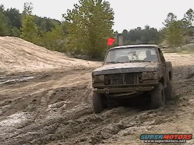 1988 Ford Bronco driving through mud, front view