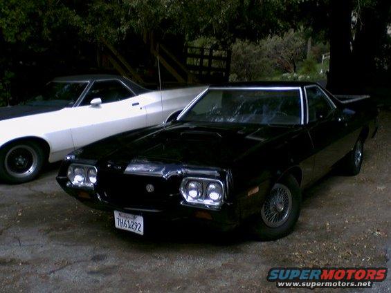 Black coupe utility with wire wheels parked next to a white one. License plate TH61292