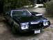1972 Ford Ranchero - A black 1972 Ford Ranchero is viewed from a three-quarter front angle, showing its distinctive grille and hood.