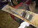 1989 Ford Bronco - A close-up view of a detached bumper trim piece, showing signs of wear and tear with rust and oil.