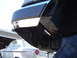 1989 Ford Bronco - Close-up of chrome bumper trim, with a vintage car visible in the background.