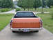 1979 Ford Ranchero - Orange 1979 Ford Ranchero pickup truck seen from the rear on a paved driveway.
