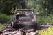 1979 Ford Bronco - Muddy 1978 Ford Bronco is stuck in a muddy off-road trail with a driver inside.