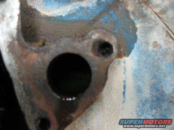 Close-up of a rusty engine part with blue paint
