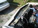 1985 Ford Crown Victoria LTD - Engine bay of a 1985 Ford Crown Victoria LTD, showing the radiator and alternator. A second vehicle is in the background.