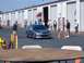 1994 Ford Probe - A gray sedan navigates a course marked by orange cones in front of a row of storage units.
