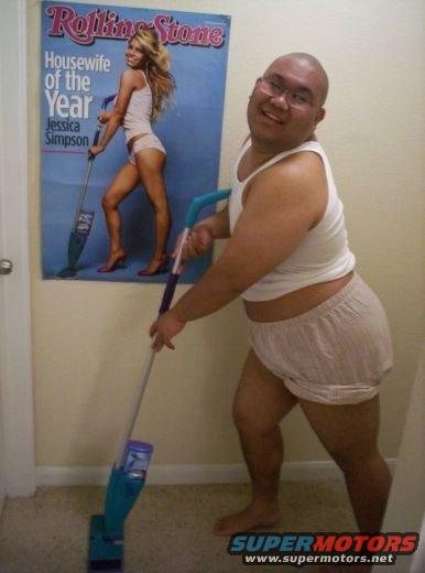 Guy in underwear holding a mop in front of a Rolling Stone magazine cover of Jessica Simpson