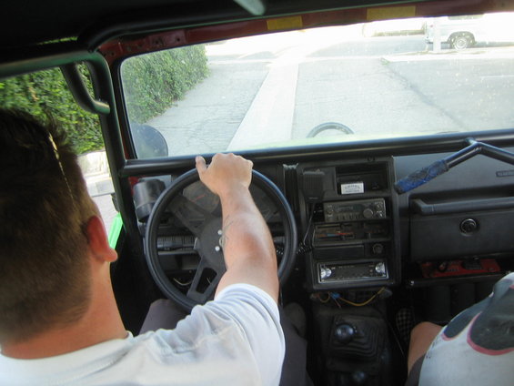 Interior view of a vehicle with a roll cage and aftermarket radio