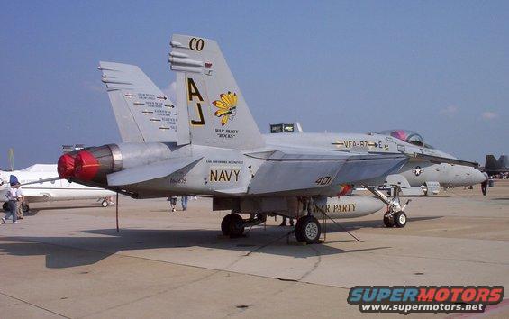 Gray F/A-18 Hornet fighter jet with 'NAVY' and 'WAR PARTY' markings
