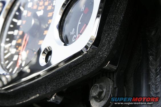 busa9a.jpg Once the screws are tight, install the new foam weather seal around the bottom and sides of the bezel.  It should attach just above the screw heads and the tabs at the corners, and reach around the top far enough to meet the inner fairing near the edge of the windshield.