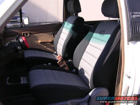1985 Toyota 4Runner interior showing front seats with Wet Okole seat covers and a red steering wheel