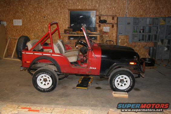 Red and black 1979 Jeep CJ5 with roll bar and spare tire on rear