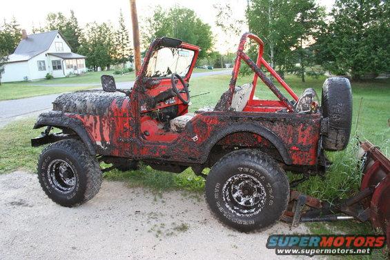 Mud-covered red 1979 Jeep CJ5 side view