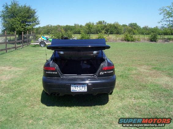 Black 1998 Dodge Avenger with trunk open, parked on grass. Rear view